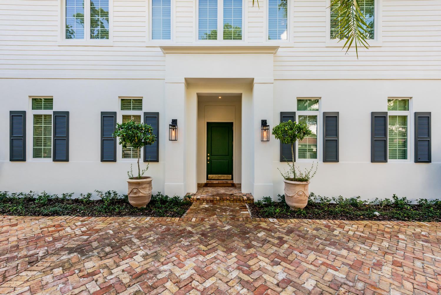 White colonial-style facade with herringbone brick entry