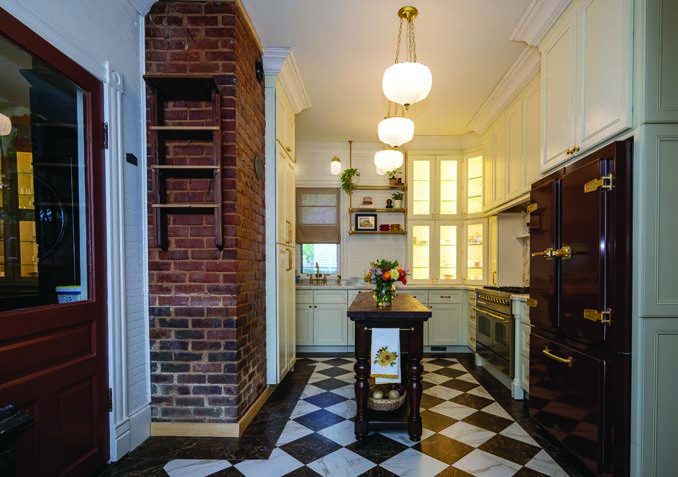 The remodeled kitchen still retains the original fireplace.