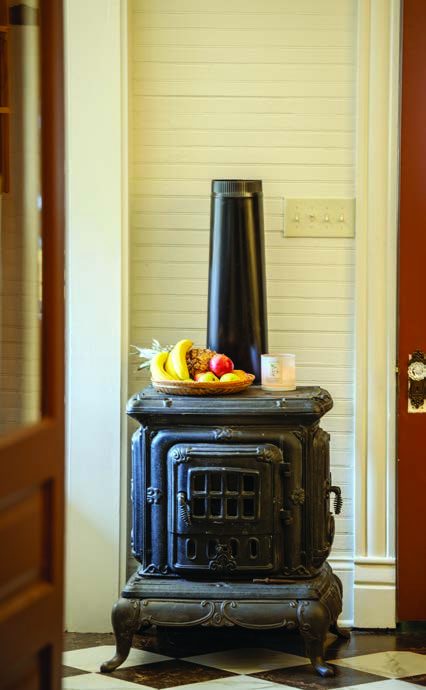 A wood-burning parlor stove that will eventually heat the kitchen.